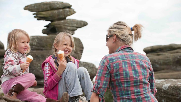 Two girls eating ice cream with a woman at Brimham Rocks